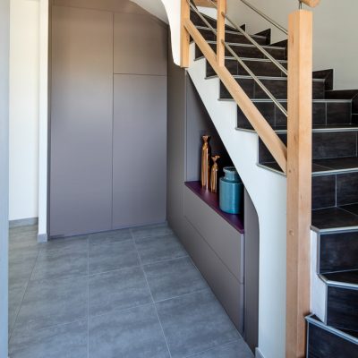 Placard sous-escalier sur-mesure taupe avec une niche et une jolie découpe - vue de droite et portes fermées